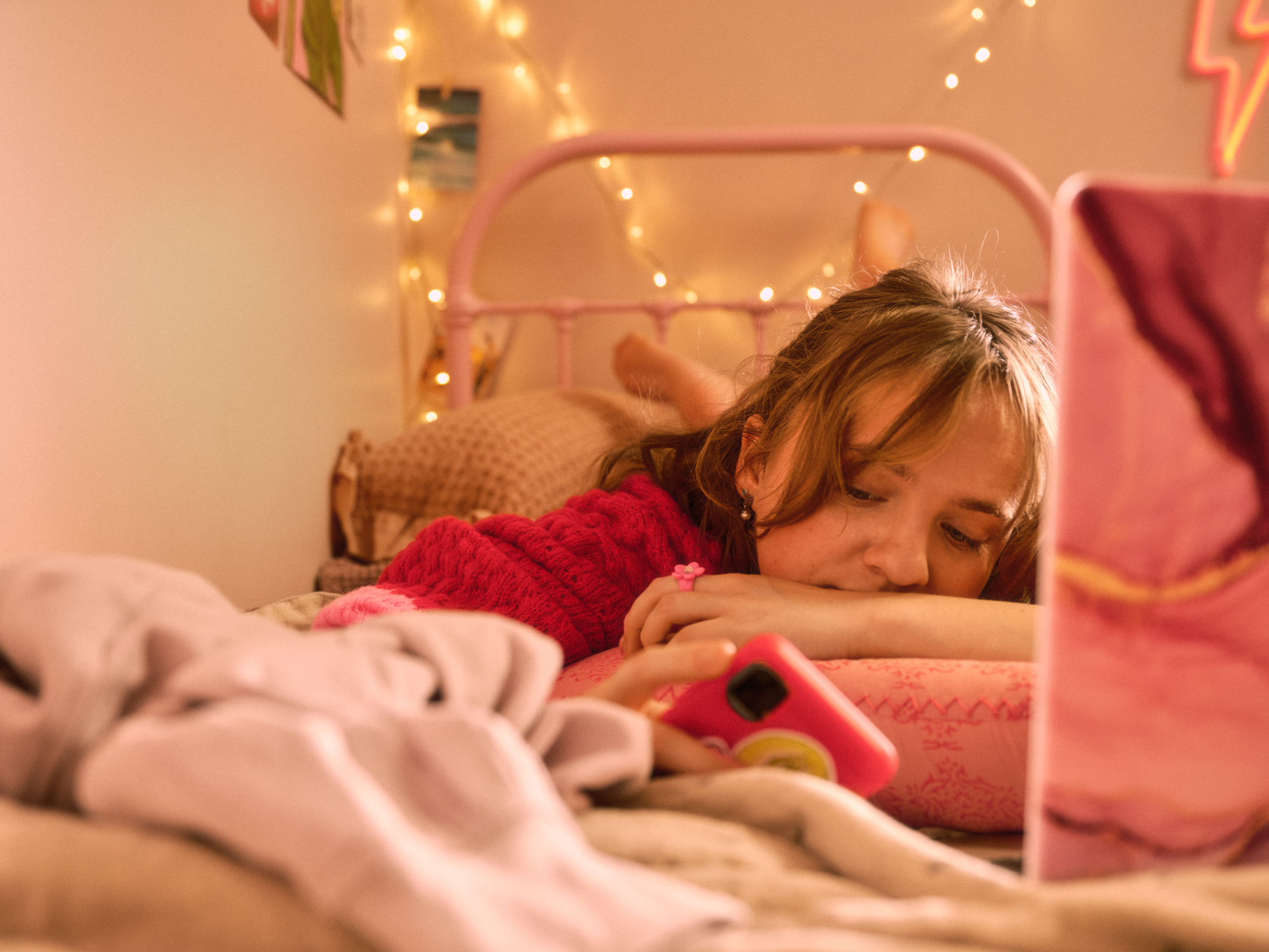 Photo of girl on her bed with phone in hand
